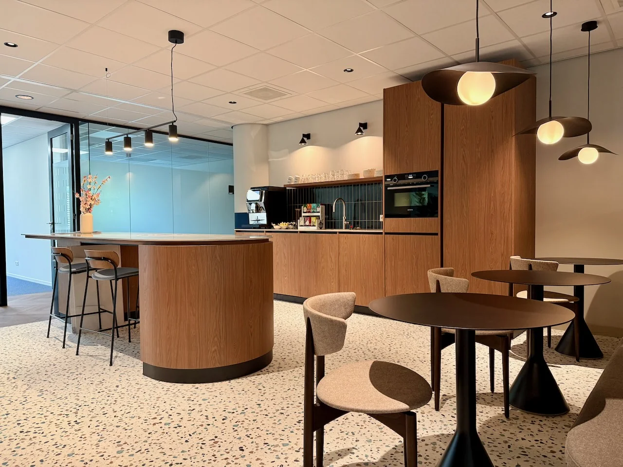 Moderne loungehoek in Kronenburg Offices met zithoeken, keukeneiland en houtaccenten.