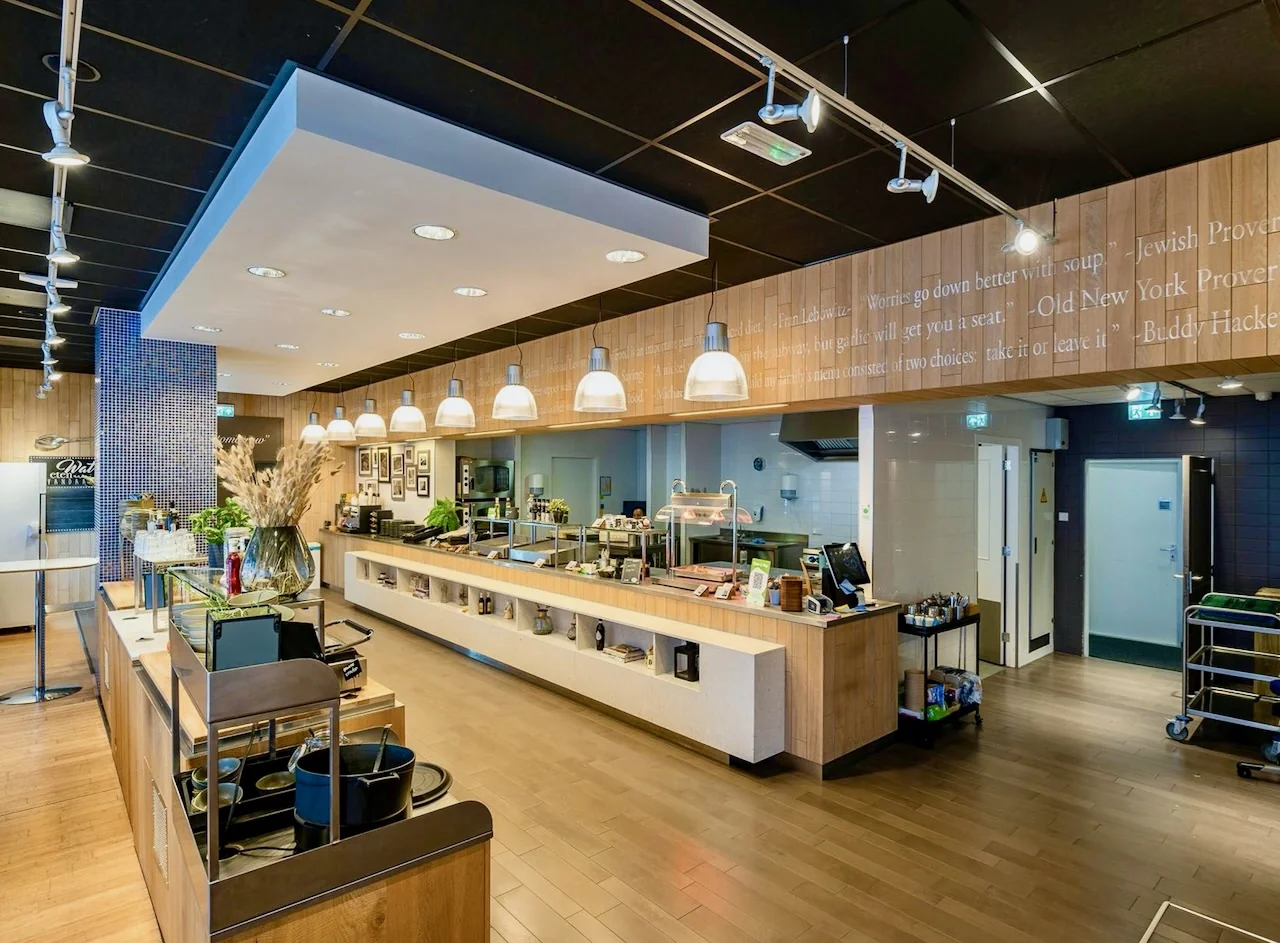 Modern restaurantinterieur van Kronenburg Offices Amstelveen met open keuken en zelfbedieningsbuffet.
