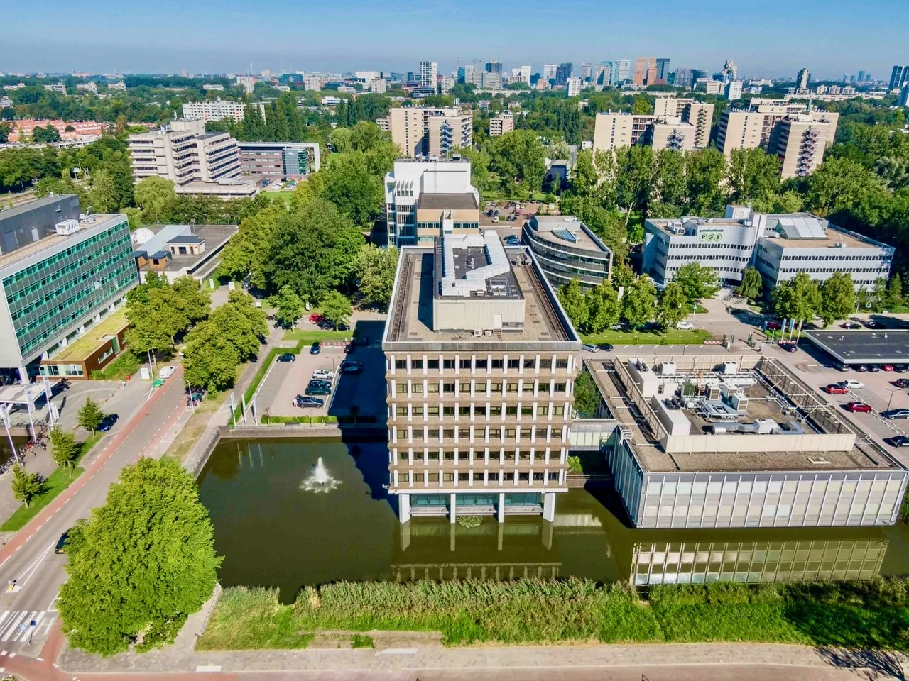 Luchtfoto van het Kronenburg Offices gebouw in Amstelveen, omgeven door water, groen en andere kantoorpanden.