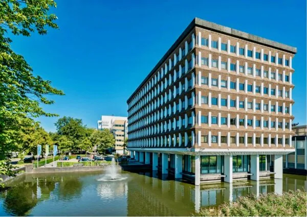 Kantoorgebouw Kronenburg Offices Amstelveen gebouw 03 met spiegelende ramen, gelegen aan een vijver met fontein.