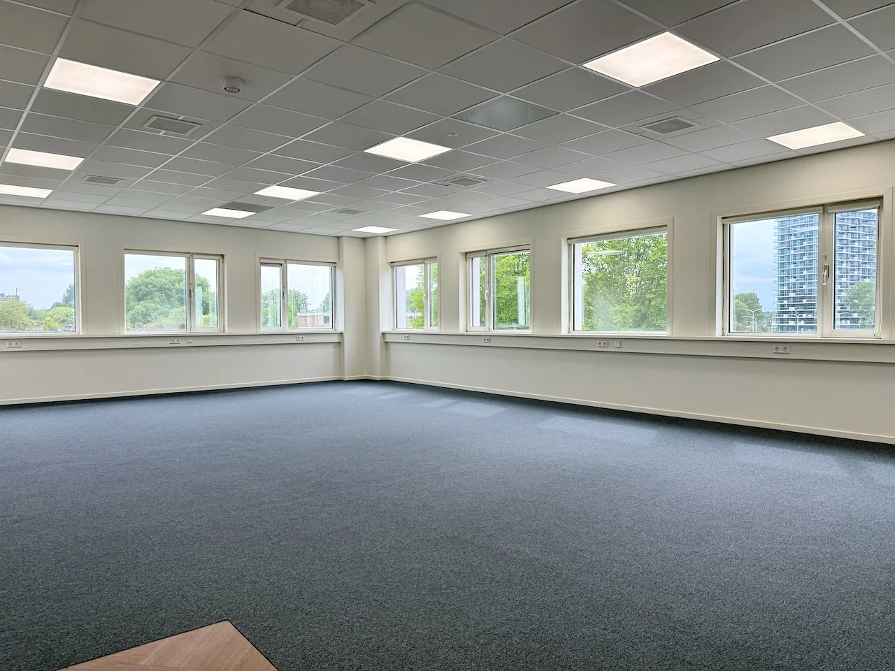 Lichte, leegstaande kantoorruimte op de hoek van Kronenburg Offices met ramen aan twee zijden.