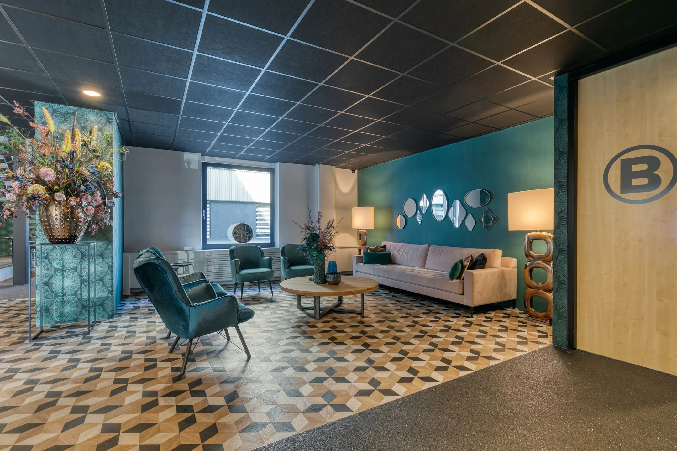 Stijlvolle wachtruimte aan de Laapvelderweg 15 met retro meubels, geometrische vloer en een groene accentmuur met spiegels.