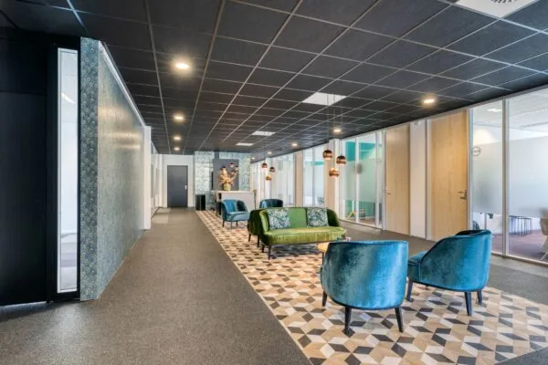 Stijlvol ingerichte wachtruimte op Laapvelderweg 15 met fluwelen stoelen, een groene bank en moderne verlichting.