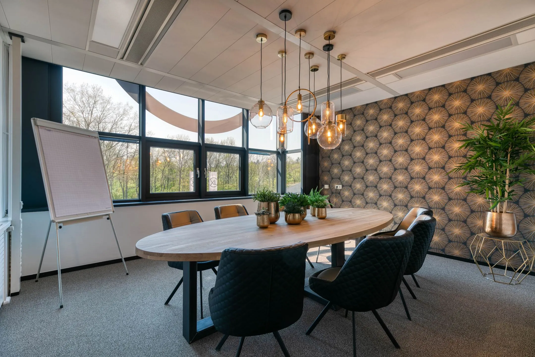 Stijlvolle vergaderruimte aan de Laapvelderweg 15 met ovale houten tafel, moderne verlichting en decoratieve wand.