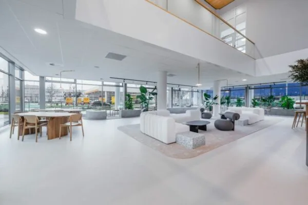Moderne, licht ingerichte lobby met zitgelegenheden en grote ramen aan de Laarderhoogtweg 7.