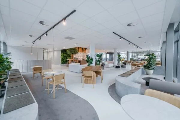 Moderne en open kantoorruimte aan de Laarderhoogtweg 7 met stijlvolle zitruimtes, veel daglicht en groene accenten.