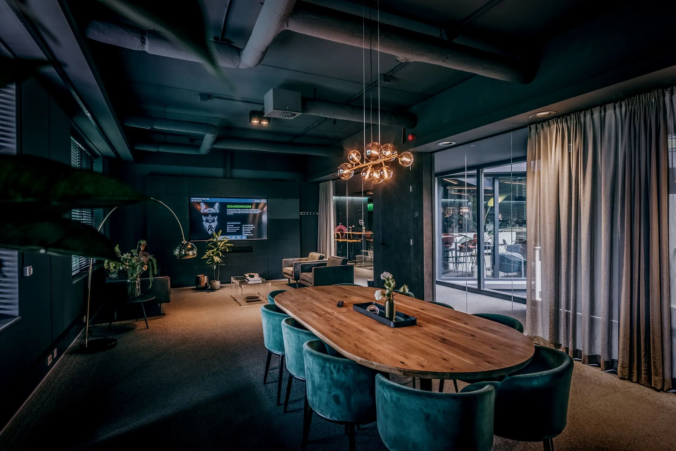 Stijlvol ingerichte vergaderruimte aan de Lange Amerikaweg 61 met houten tafel, fluwelen stoelen en moderne verlichting.