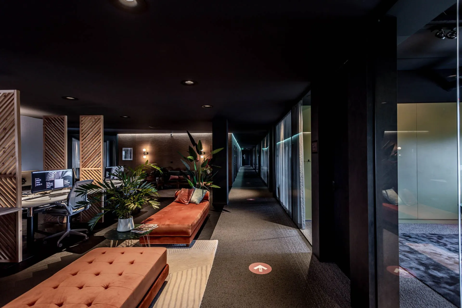 Modern ingericht kantoorinterieur aan de Lange Amerikaweg 61 met werkplekken, zitbanken en sfeervolle verlichting.