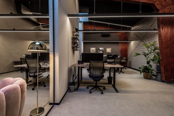 Modern ingericht kantoor aan de Lange Amerikaweg 61 met houten accenten, designverlichting en werkplekken met bureaustoelen en computers.