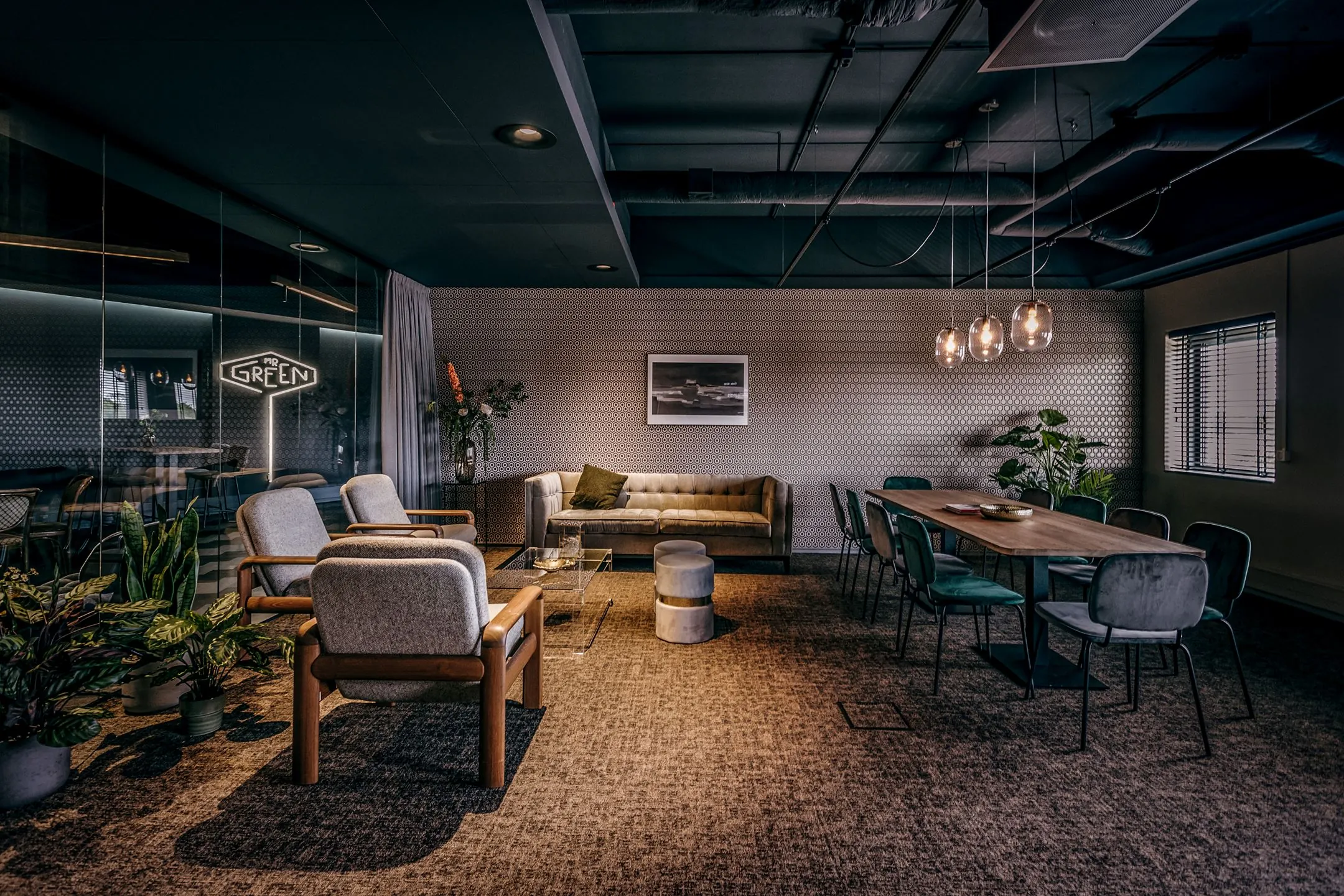 Stijlvol ingerichte vergaderruimte aan de Lange Amerikaweg 61 met zithoek, lange houten tafel en moderne verlichting.