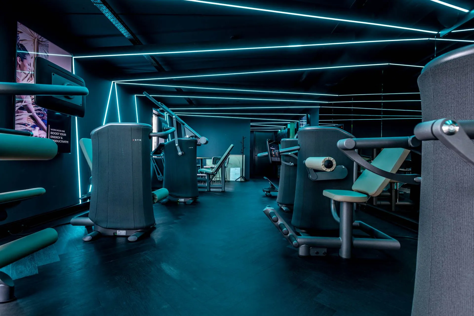 Moderne fitnessruimte aan de Lange Amerikaweg 61 met geavanceerde krachttrainingsapparatuur en sfeervolle blauwe LED-verlichting.