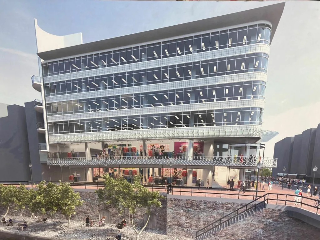 Moderne winkel- en kantoorgebouw aan de Lange Viestraat met glazen gevel en overhangende etages boven een stadsplein en gracht.