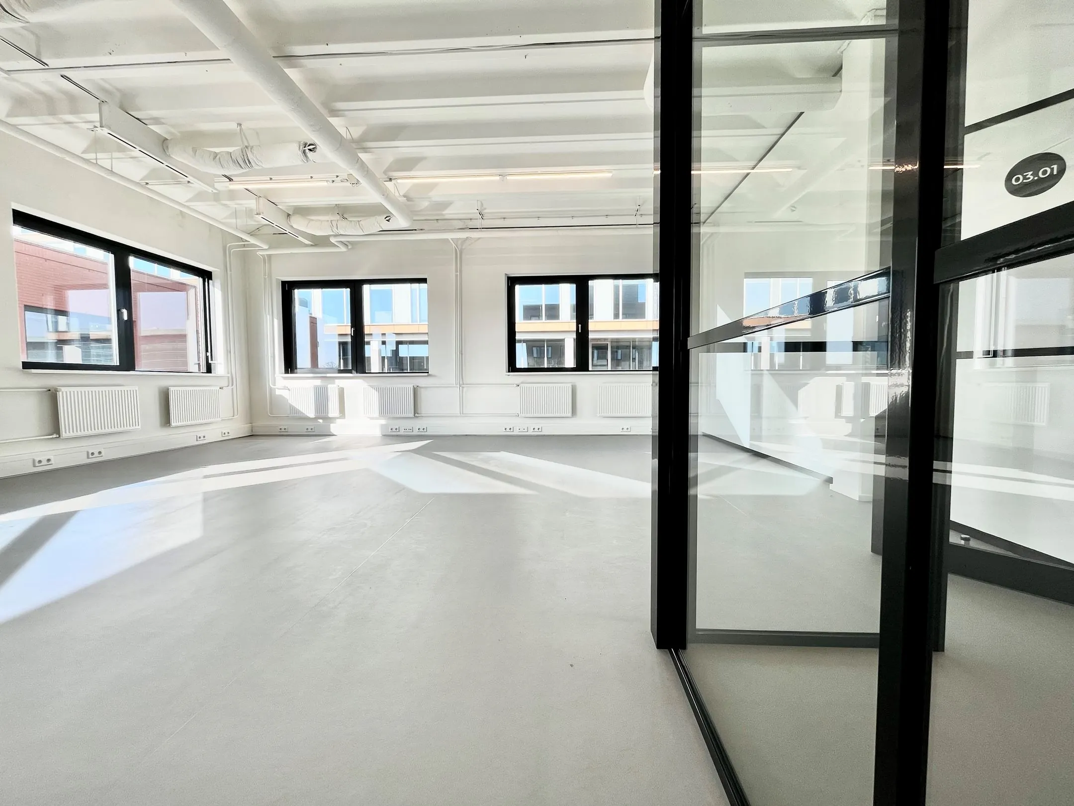 Lichte, moderne kantoorruimte aan de Langekleiweg met grote ramen en glazen scheidingswanden.
