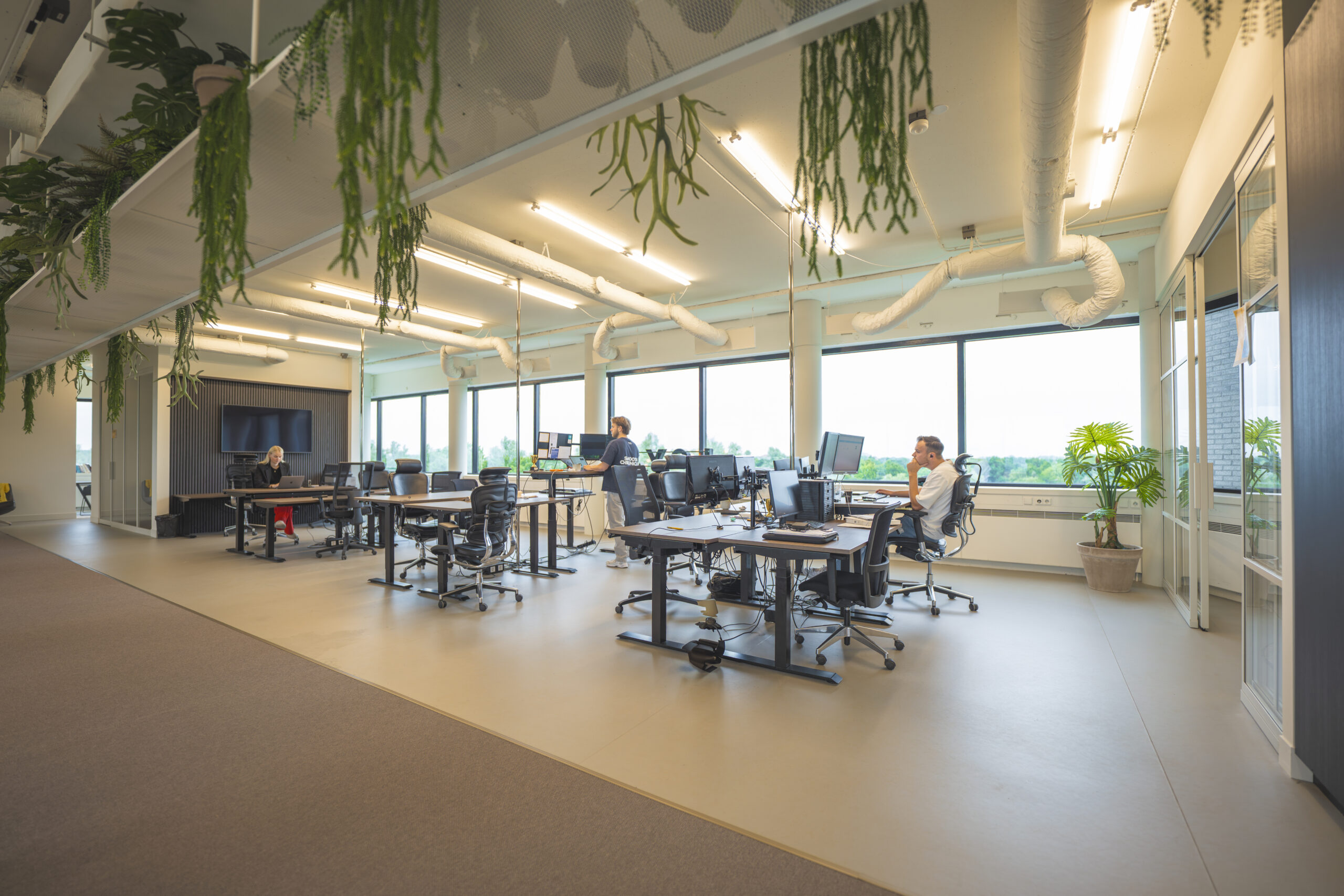 Moderne en open kantoorruimte van Loyal Interim met bureaus, computers en enkele medewerkers aan het werk.