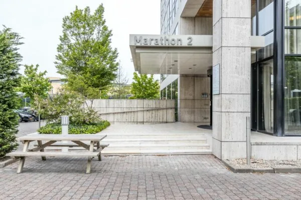 Ingang van kantoorgebouw Marathon 2 met trap, overkapping en een buitentafel op de voorgrond.