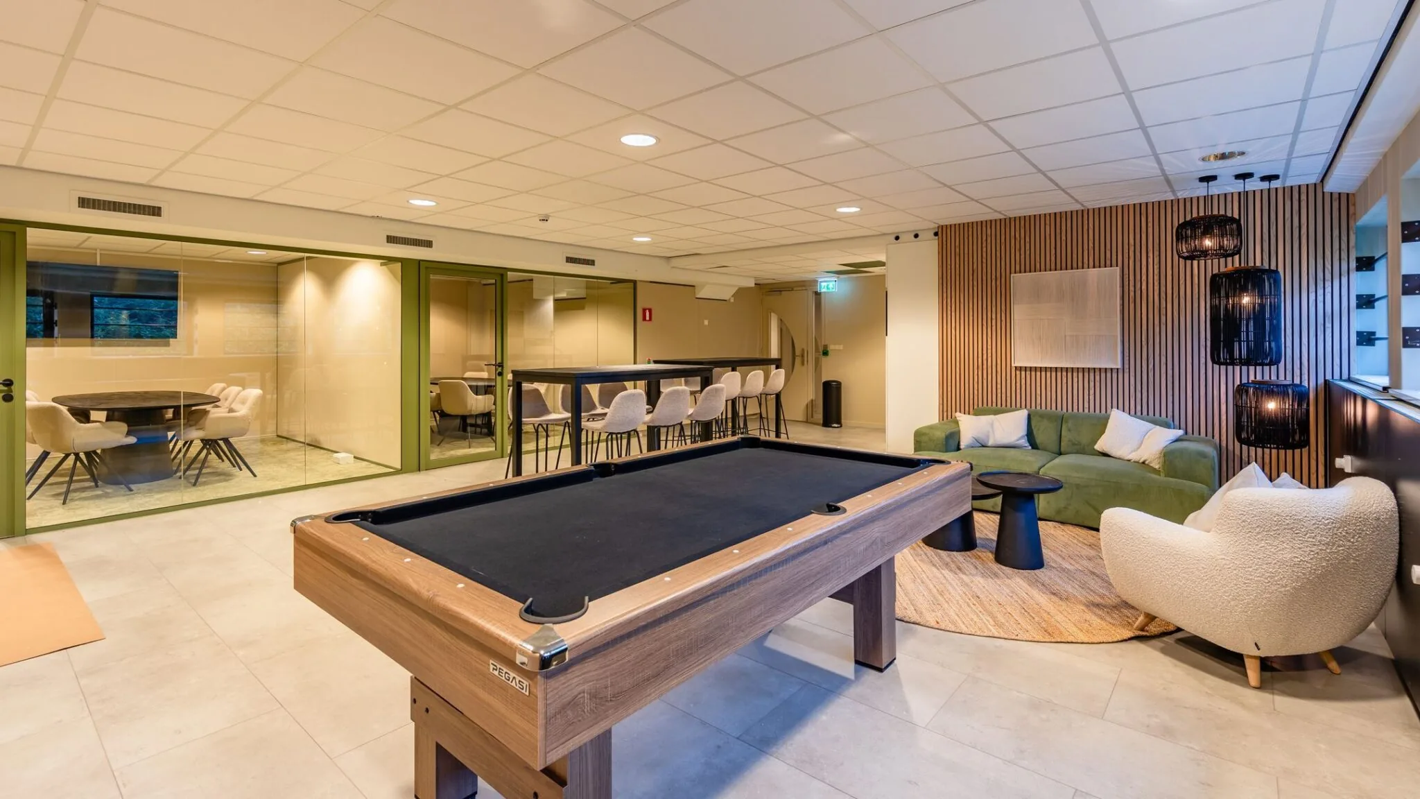 Moderne lounge- en vergaderruimte met pooltafel, zithoek en glazen vergaderzalen in Marathon 2.