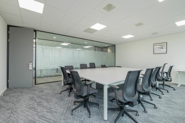 Moderne vergaderruimte in Mendelweg 32 met een grote witte tafel en ergonomische bureaustoelen.