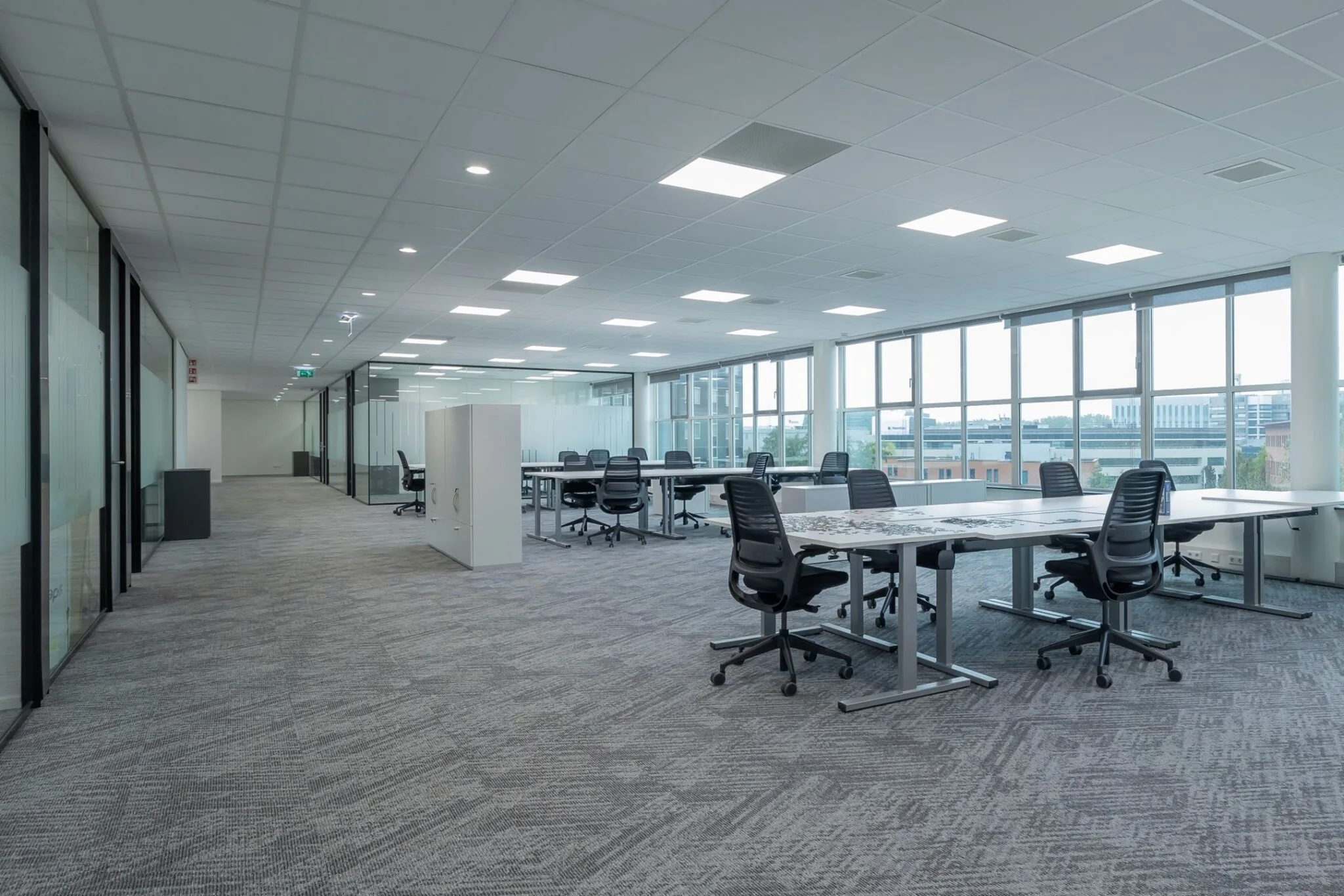 Moderne, open kantoorruimte op Mendelweg 32 met bureaus, ergonomische stoelen en grote raampartijen.
