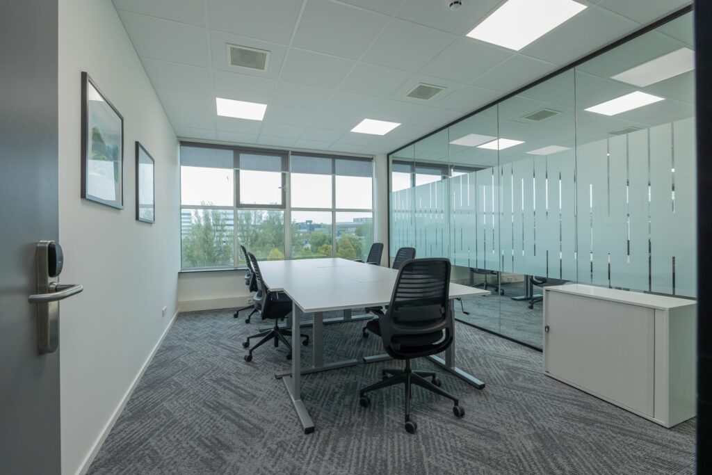 Vergaderruimte met zes bureaustoelen, een grote tafel en een glazen wand in het kantoor aan de Mendelweg 32.