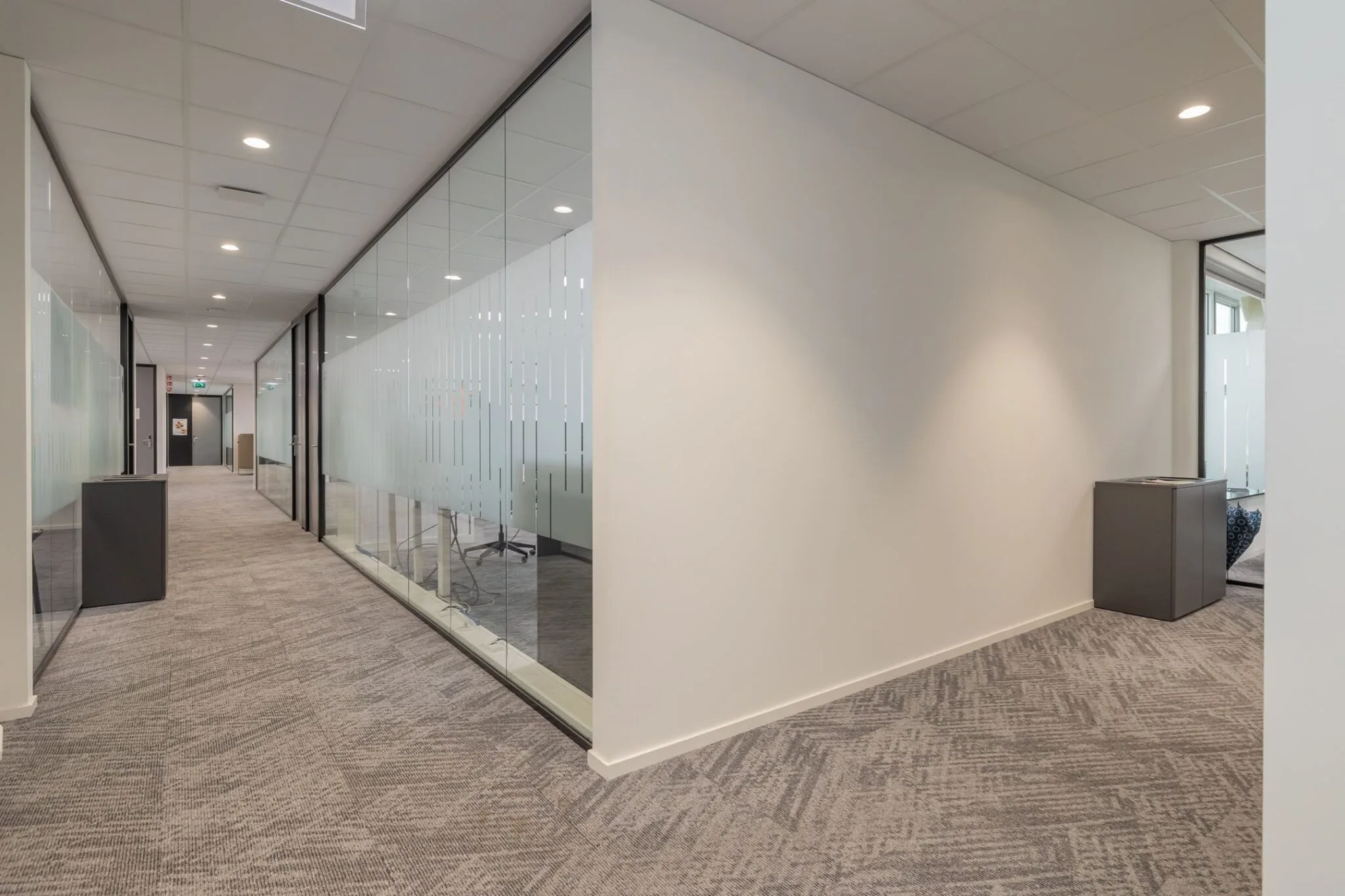 Modern kantoorinterieur met een gang en glazen wanden bij Mendelweg 32.