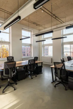 Moderne, lichte kantoorruimte in Mindspace Utrecht met bureaus, ergonomische stoelen en grote ramen.