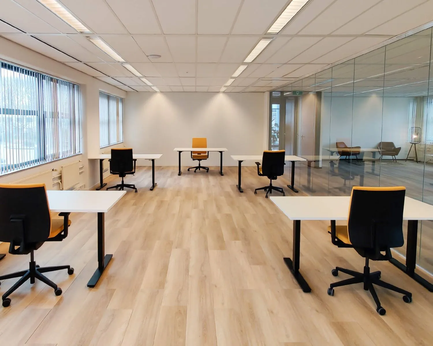 Moderne vergaderruimte in Utrecht met zes werkplekken, bureaustoelen en glazen wand.