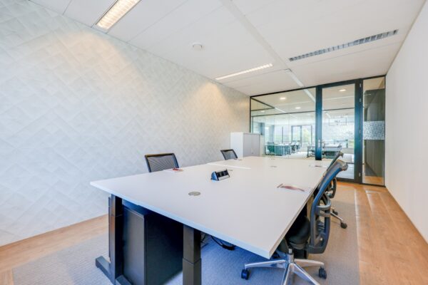 Moderne privé-kantoorruimte met een grote vergadertafel en stoelen in Tribes Amsterdam.
