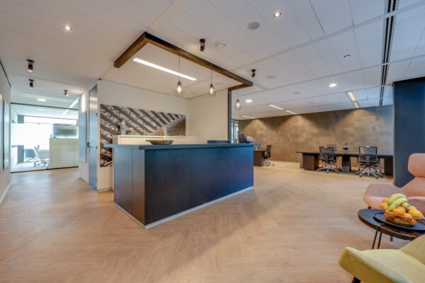 Ontvangstruimte van Tribes Amsterdam met een moderne balie en zitgelegenheid.