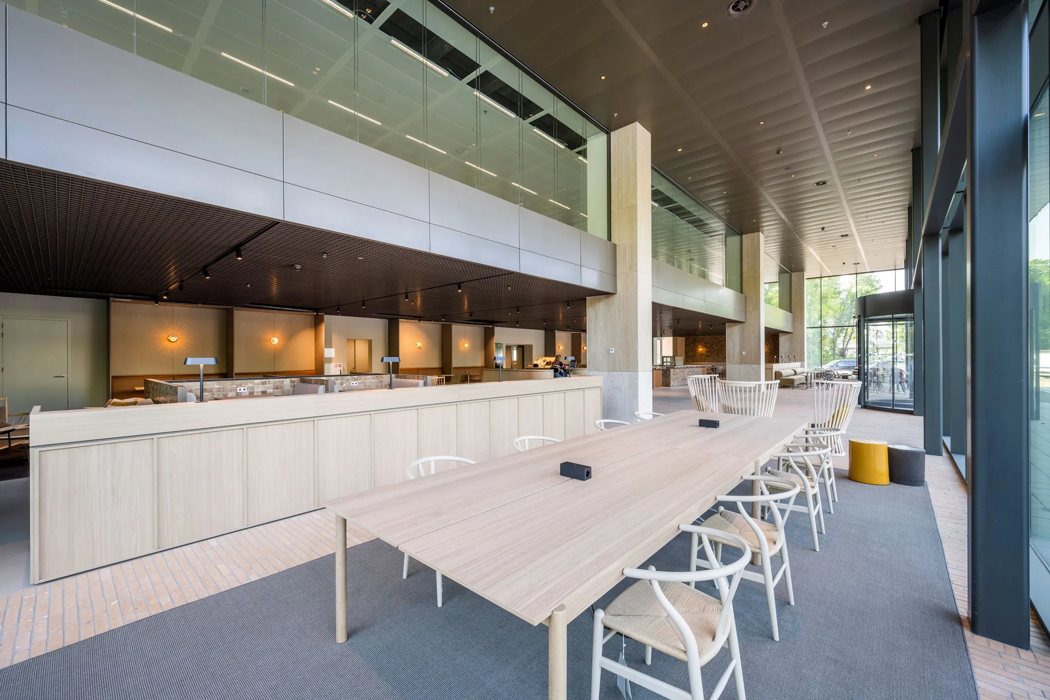 Moderne, open kantoorruimte met houten tafels, designstoelen en grote ramen aan de Nachtwachtlaan 20.