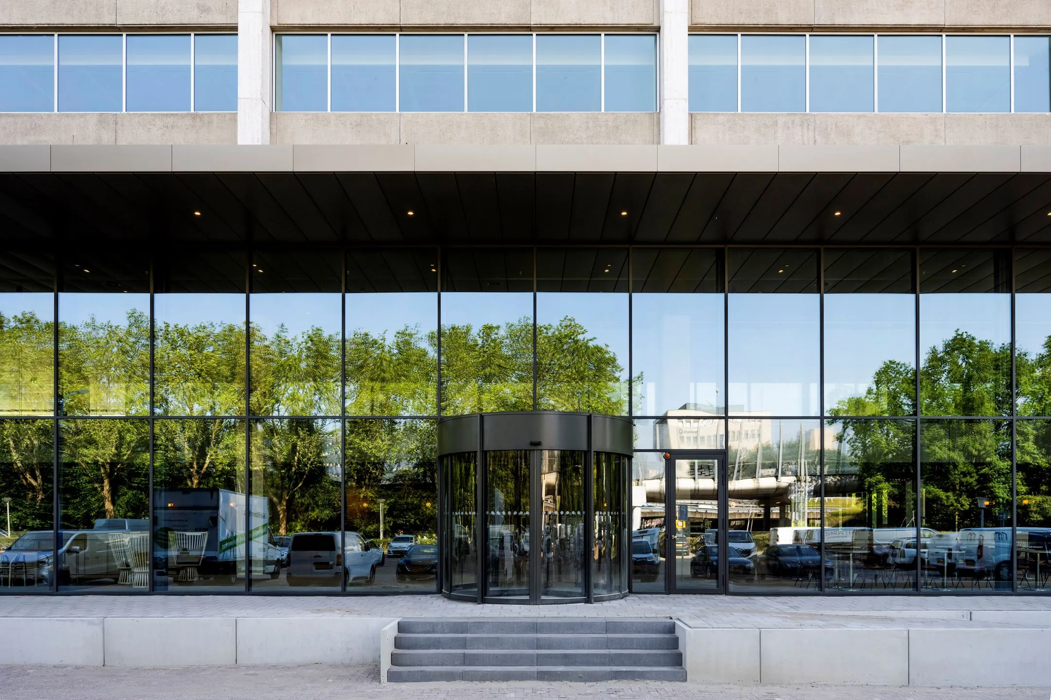 Voorgevel van het kantoorgebouw aan de Nachtwachtlaan 20 met een glazen entree en draaideur.