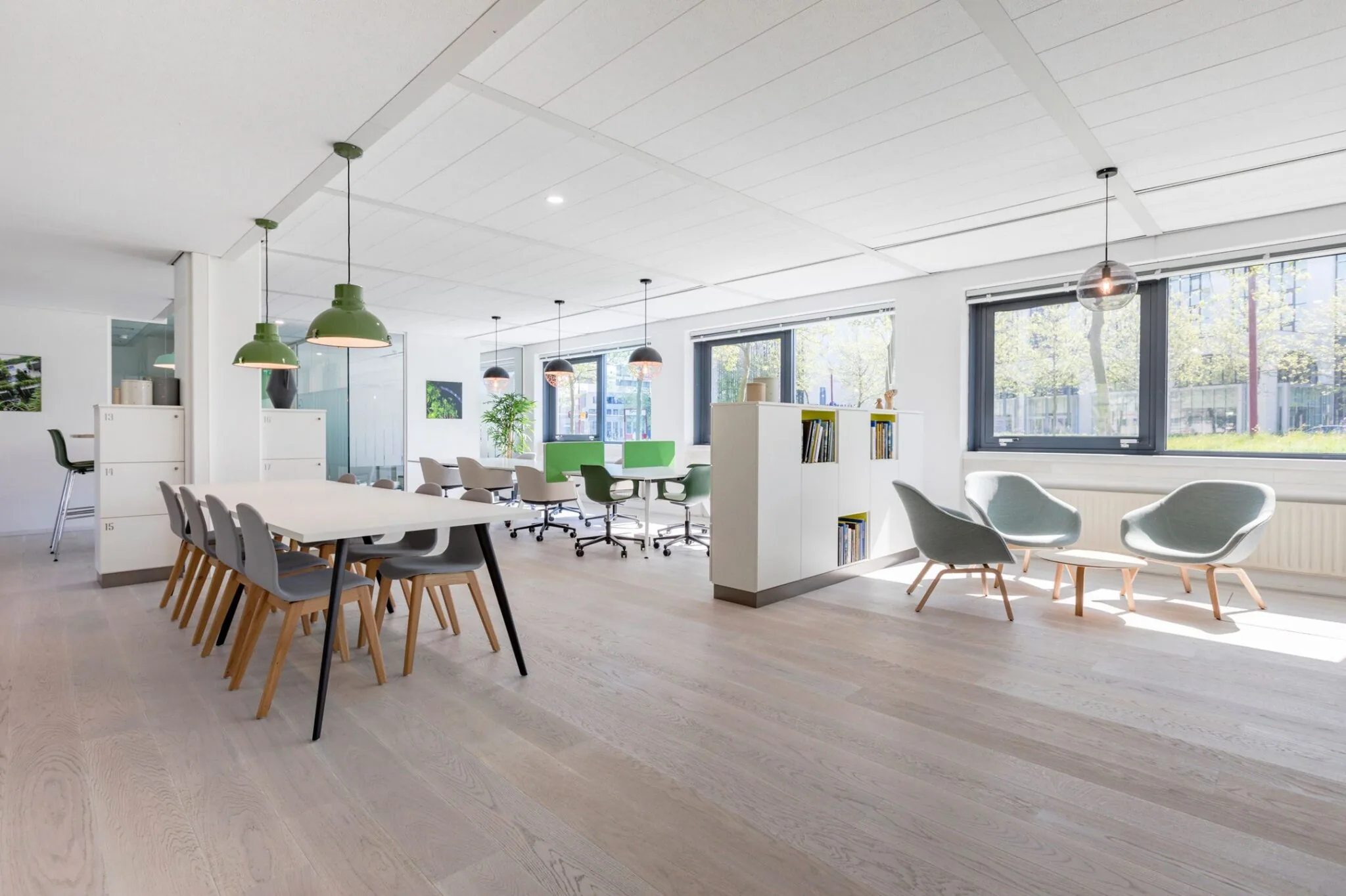 Moderne, lichte kantooruimte in Nevelgaarde 8 met vergaderplekken, zithoek en grote ramen.