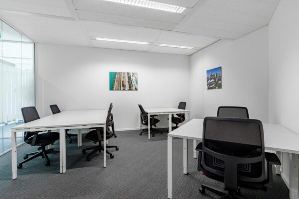 Kantoorruimte met zes bureaus en bureaustoelen in een lichte, moderne inrichting aan Nevelgaarde 8.