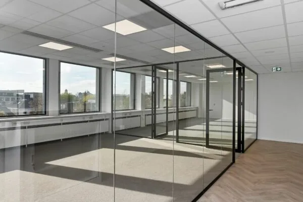 Licht en modern kantoorpand in Arnhem met glazen vergaderruimtes en grote ramen.