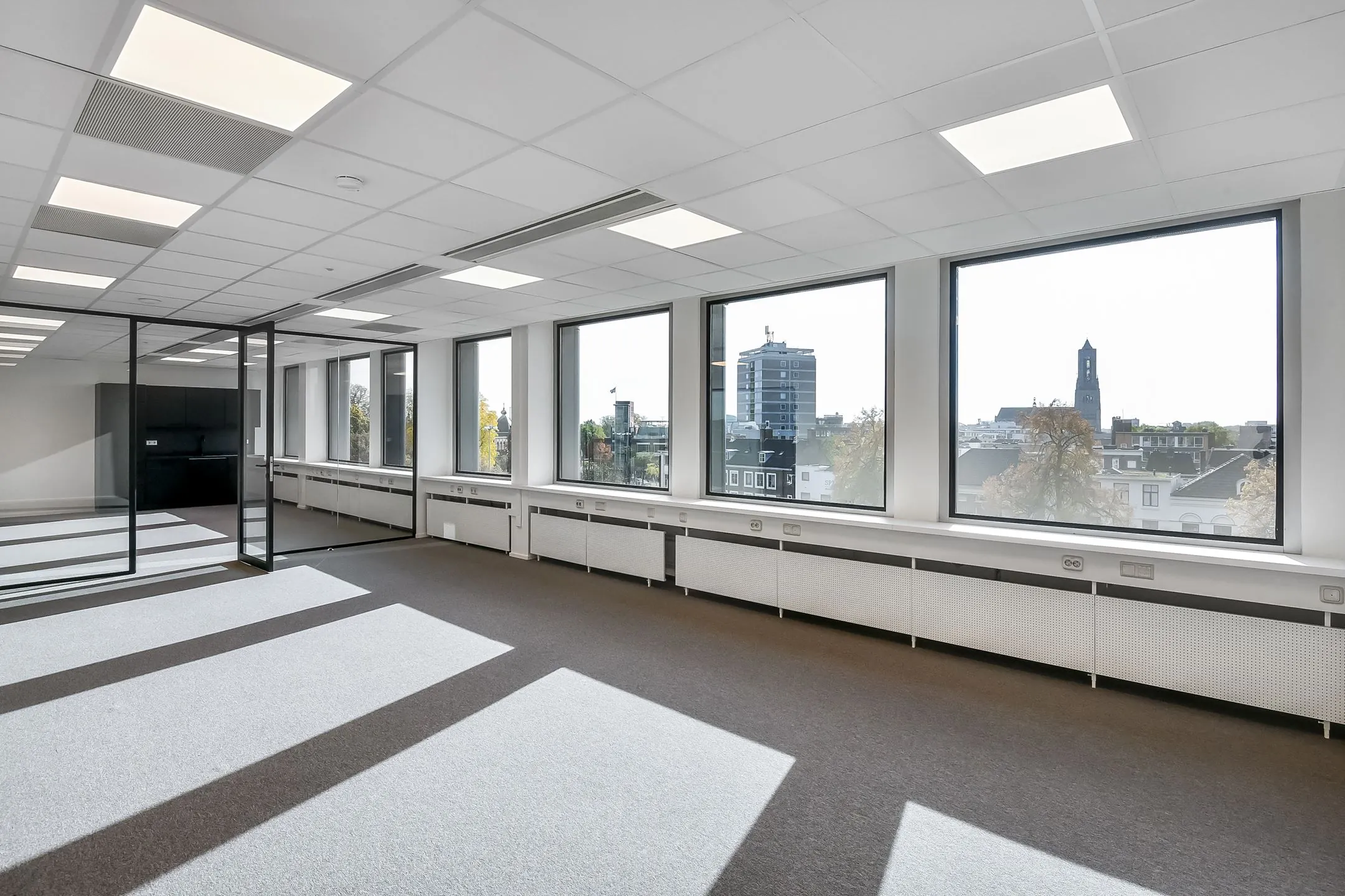 Lichte, moderne kantoorruimte in Newday Arnhem met grote ramen en uitzicht op de stad.