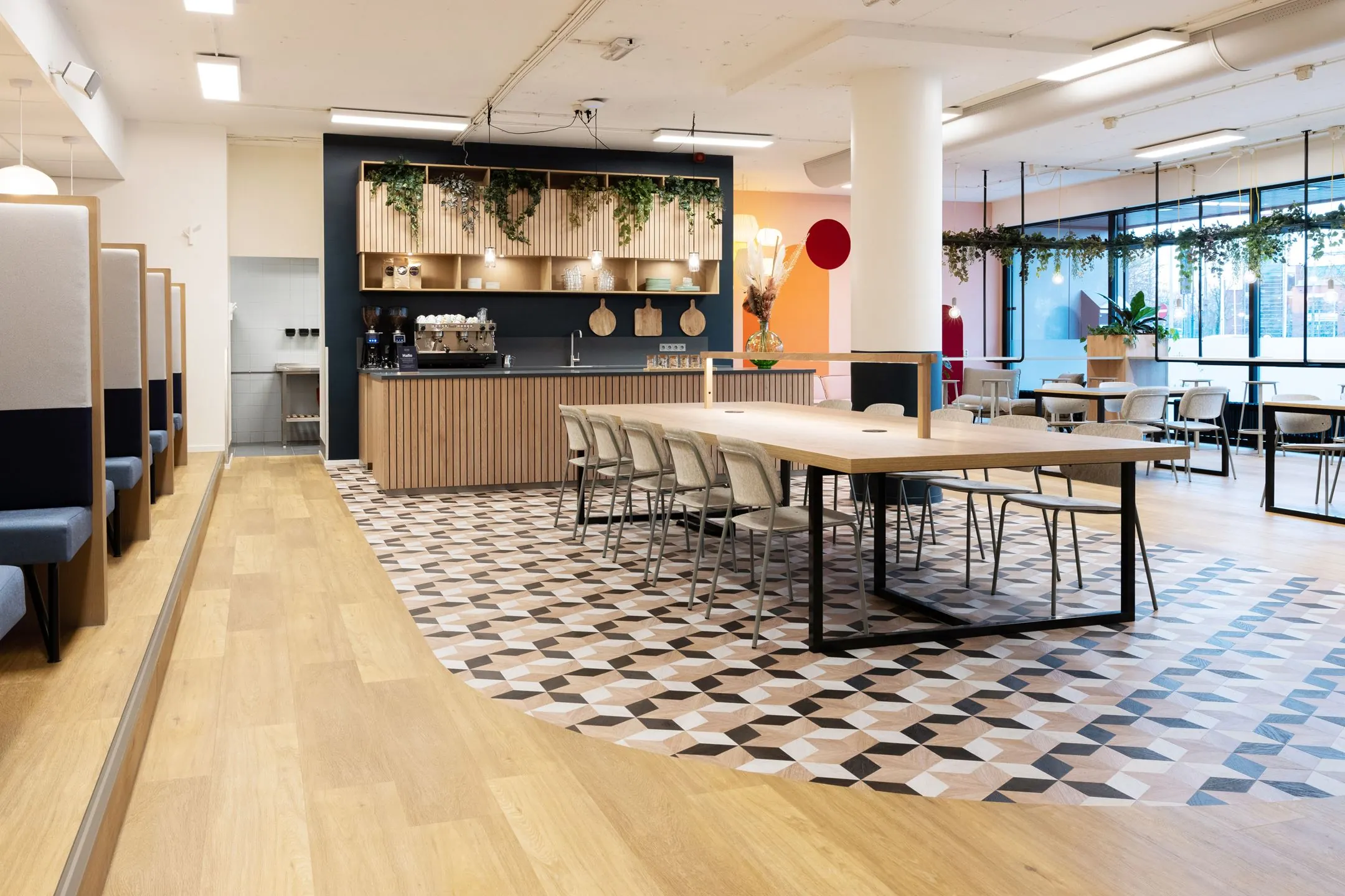 Moderne en sfeervolle kantoorruimte van Newday Arnhem met een koffiebar, lange vergadertafel en zitplekken.