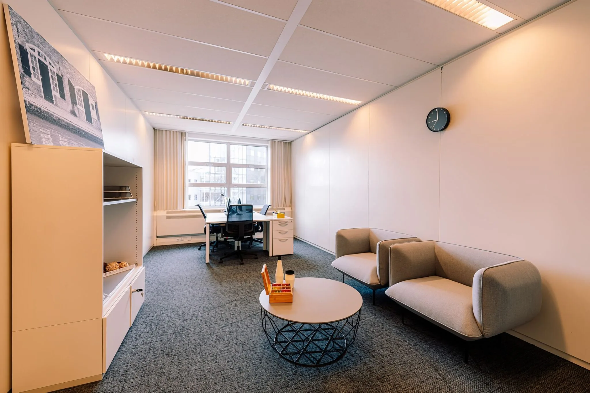 Modern ingericht kantoor aan Newtonlaan 115 met werkplek, zitgedeelte en grote raampartij.