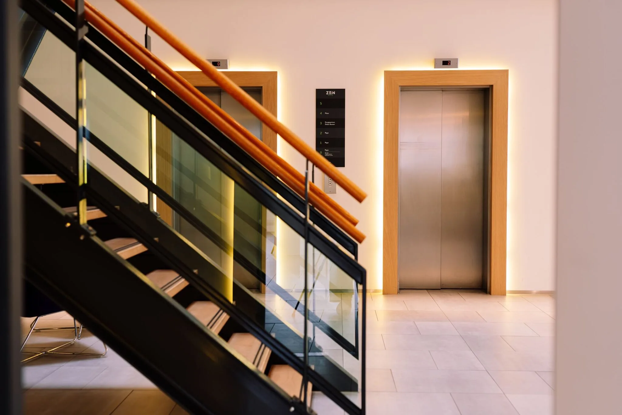 Moderne hal met een trap en twee liften in het kantoorgebouw Newtonlaan 115.