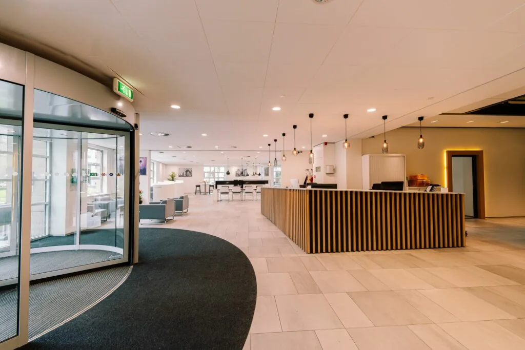 Moderne en ruime entreehal van Newtonlaan 115 met balie, zitgedeelte en hanglampen.