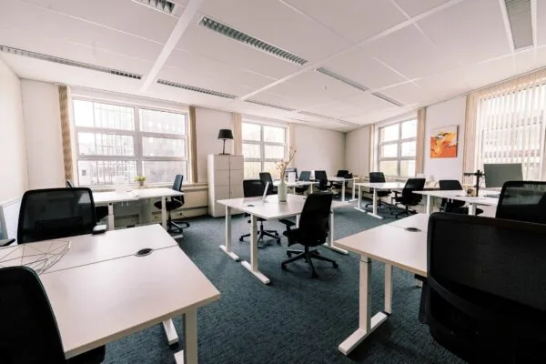 Modern en licht kantoorpand aan de Newtonlaan 115 met meerdere werkplekken en grote ramen.