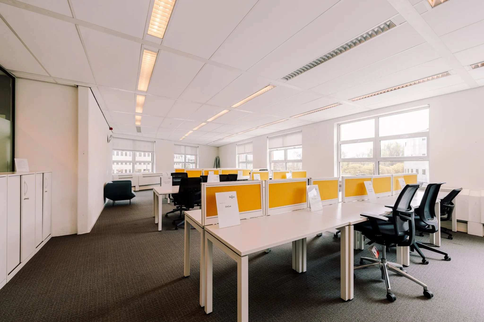 Modern kantoorgebouw aan de Newtonlaan 115 met open werkplekken, gele scheidingspanelen en veel natuurlijk licht.