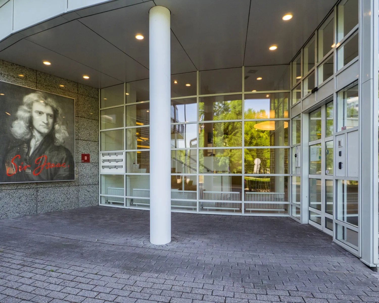 Entree van het kantoorgebouw aan de Newtonlaan met een portret van Sir Isaac Newton op de gevel.