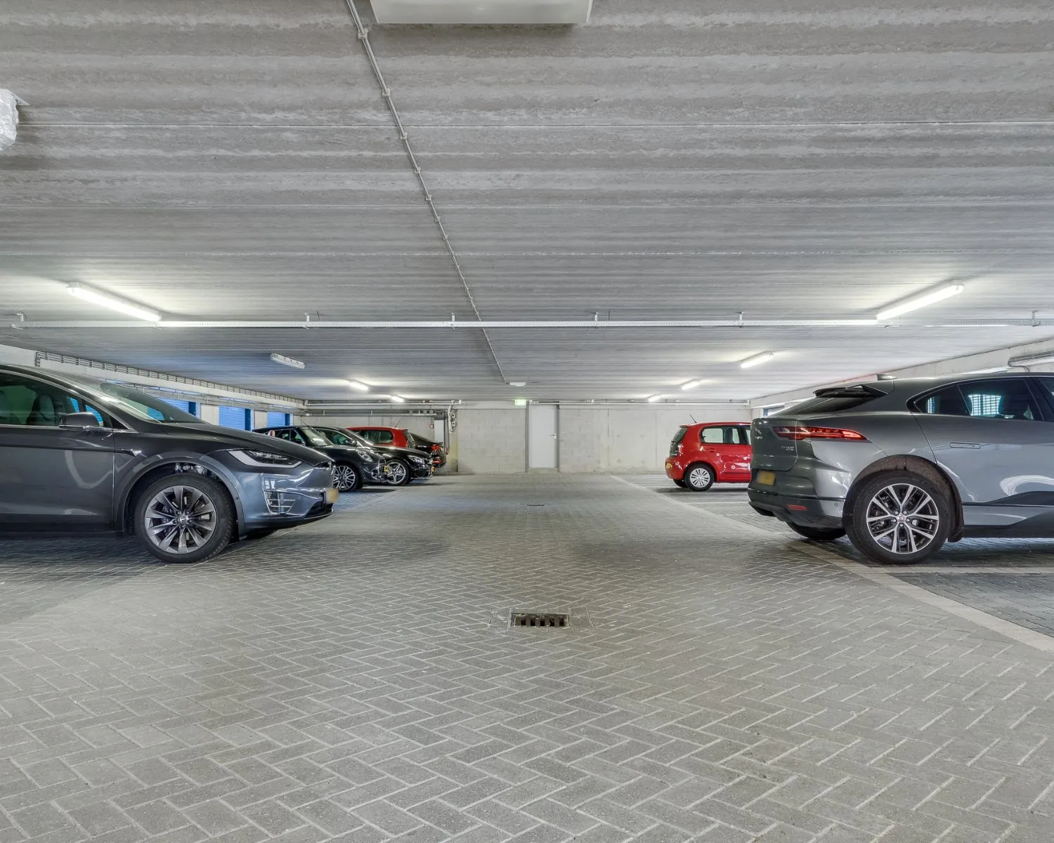 Overdekte parkeergarage met meerdere geparkeerde auto's aan de Newtonlaan.