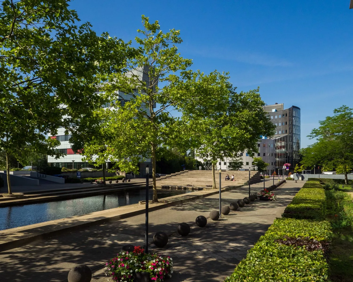 Moderne kantooromgeving aan de Newtonlaan in Utrecht met groen, waterelementen en kantoorgebouwen op een zonnige dag.