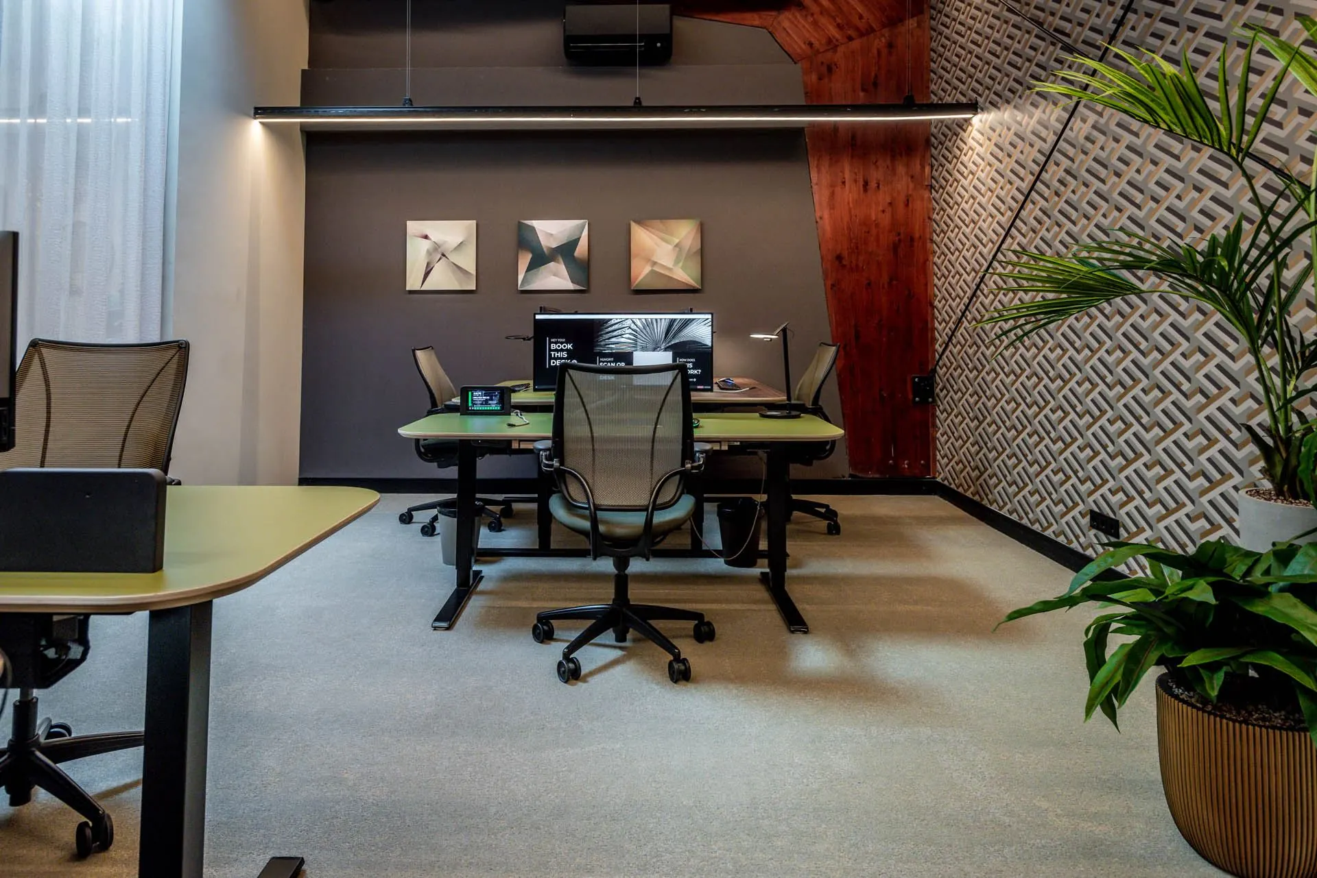 Moderne kantoorruimte aan de Oudhuizerstraat 31 met ergonomische stoelen, groene bureaus, wanddecoratie en kamerplanten.