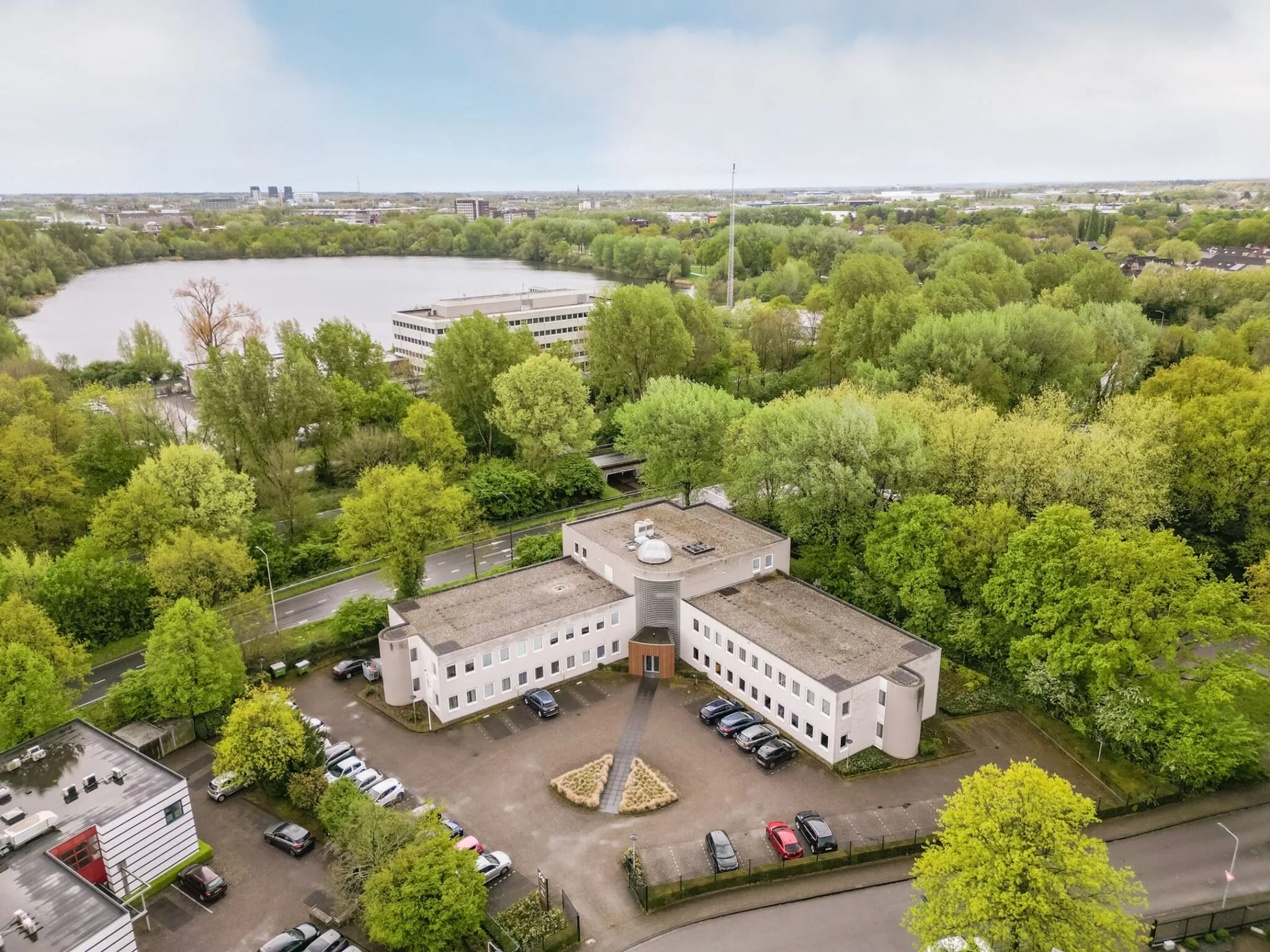 Luchtfoto van het kantoorgebouw aan Paardeweide 2A-4C, omringd door groen en met uitzicht op een grote vijver.