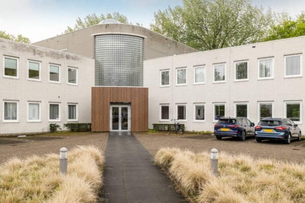 Vooraanzicht van het kantoorpand aan Paardeweide 2A-4C met entree, parkeerplaatsen en fietsenstalling.