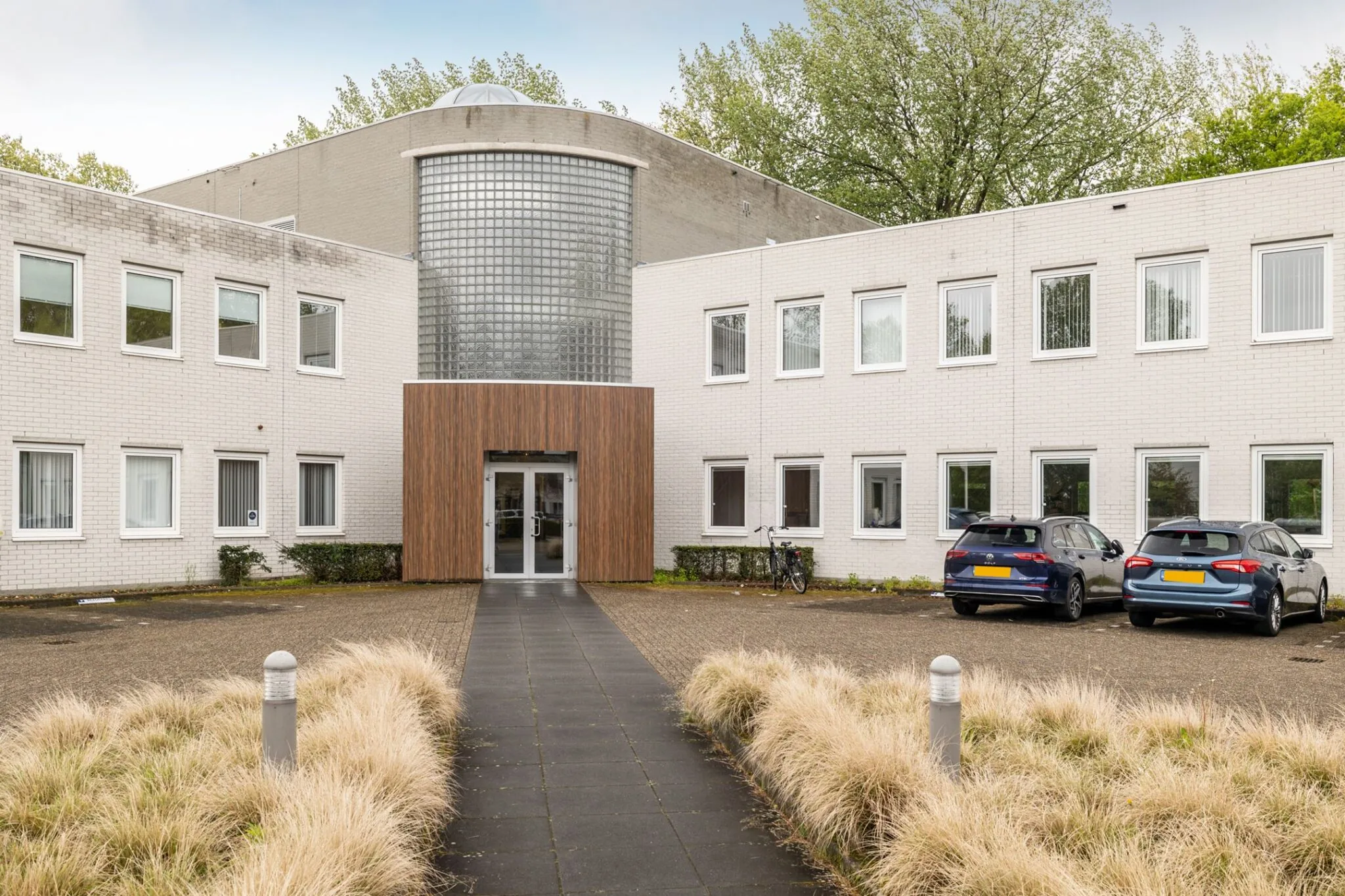 Vooraanzicht van het kantoorpand aan Paardeweide 2A-4C met entree, parkeerplaatsen en fietsenstalling.