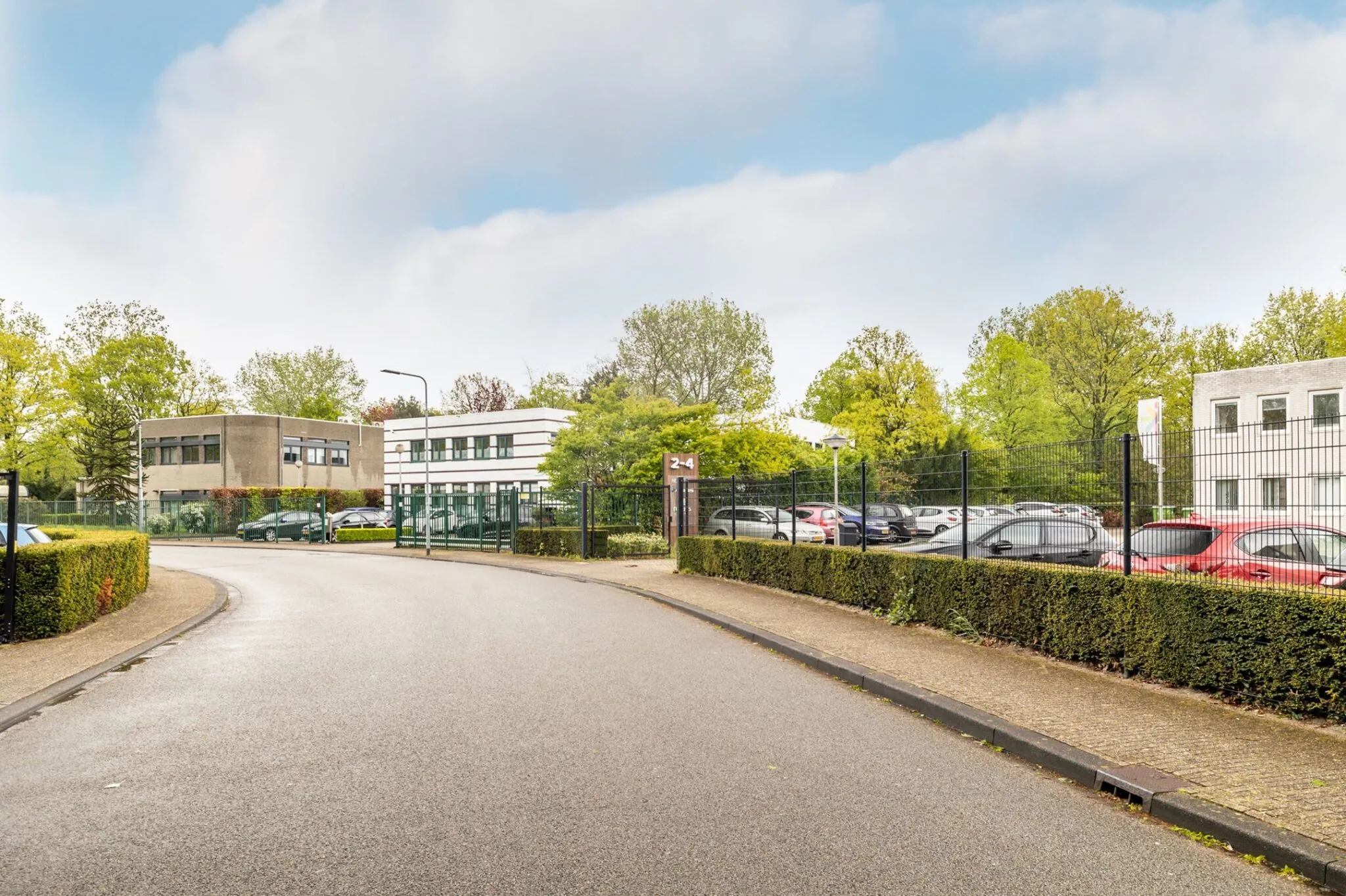Bedrijventerrein Paardeweide 2A-4C met kantoren, parkeerplaats en omheining, gezien vanaf de weg.