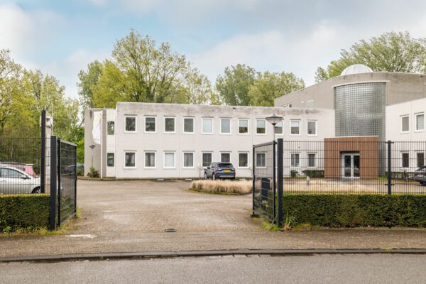 Vooraanzicht van een modern kantoorpand aan de Paardeweide 2A-4C met parkeergelegenheid en hekwerk.