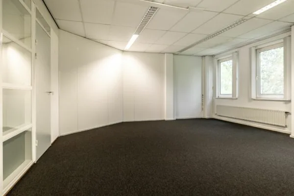 Leeg kantoorruimte met witte wanden, systeemplafond en ramen aan de rechterkant in Paardeweide 2A-4C.